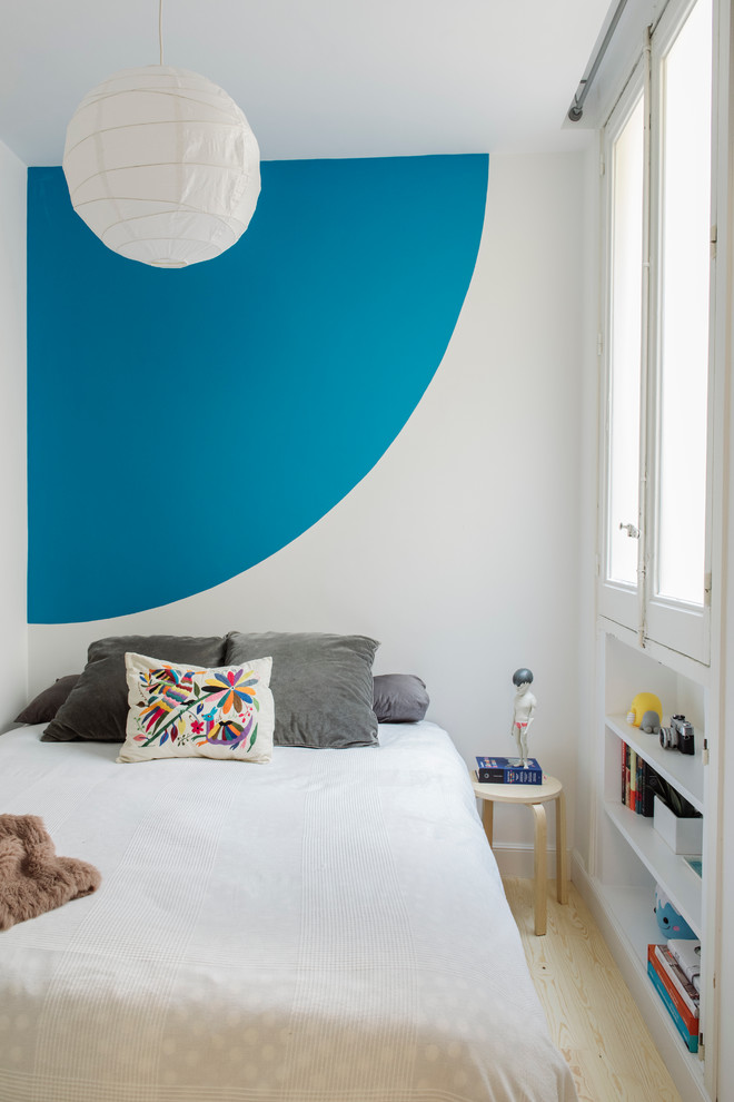 Esempio di una piccola cameretta per bambini da 4 a 10 anni minimal con pareti blu e parquet chiaro