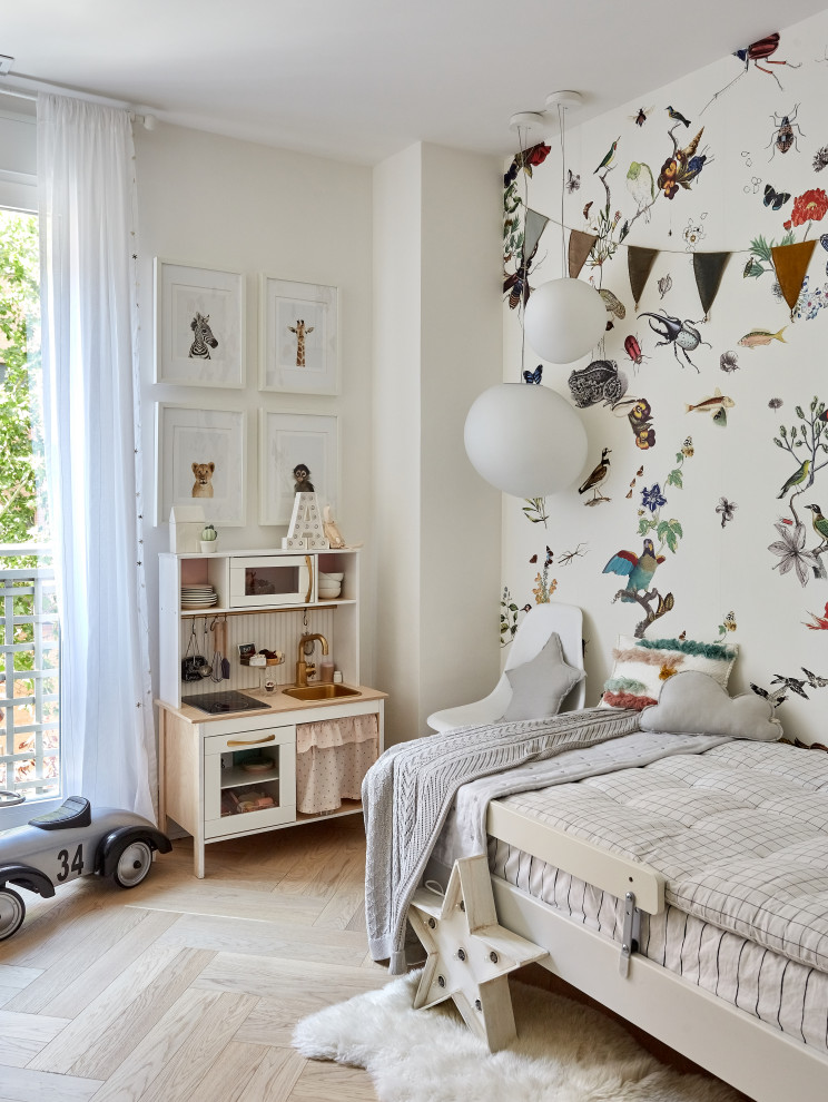Contemporary gender neutral kids' bedroom in Madrid with multi-coloured walls, light hardwood flooring, beige floors and a feature wall.