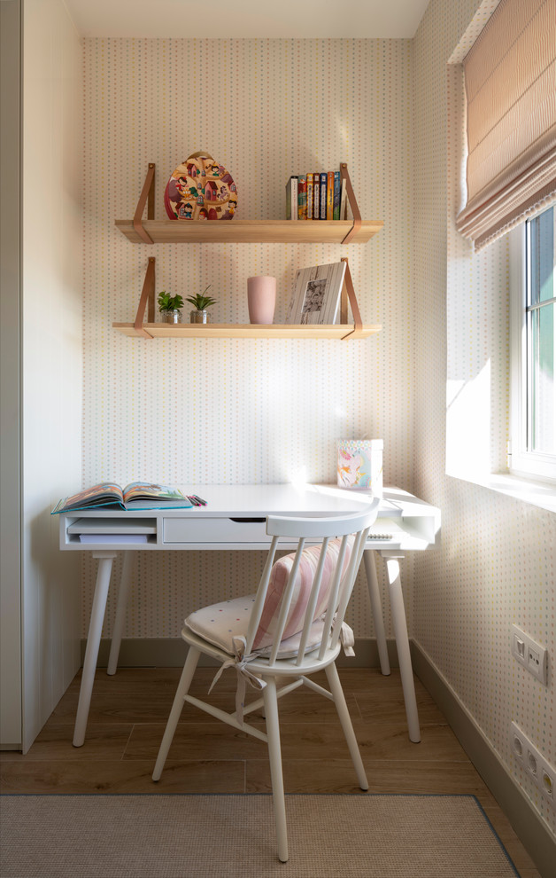 Diseño de habitación de niña de 4 a 10 años clásica renovada de tamaño medio con escritorio, paredes beige, suelo de madera clara y suelo marrón