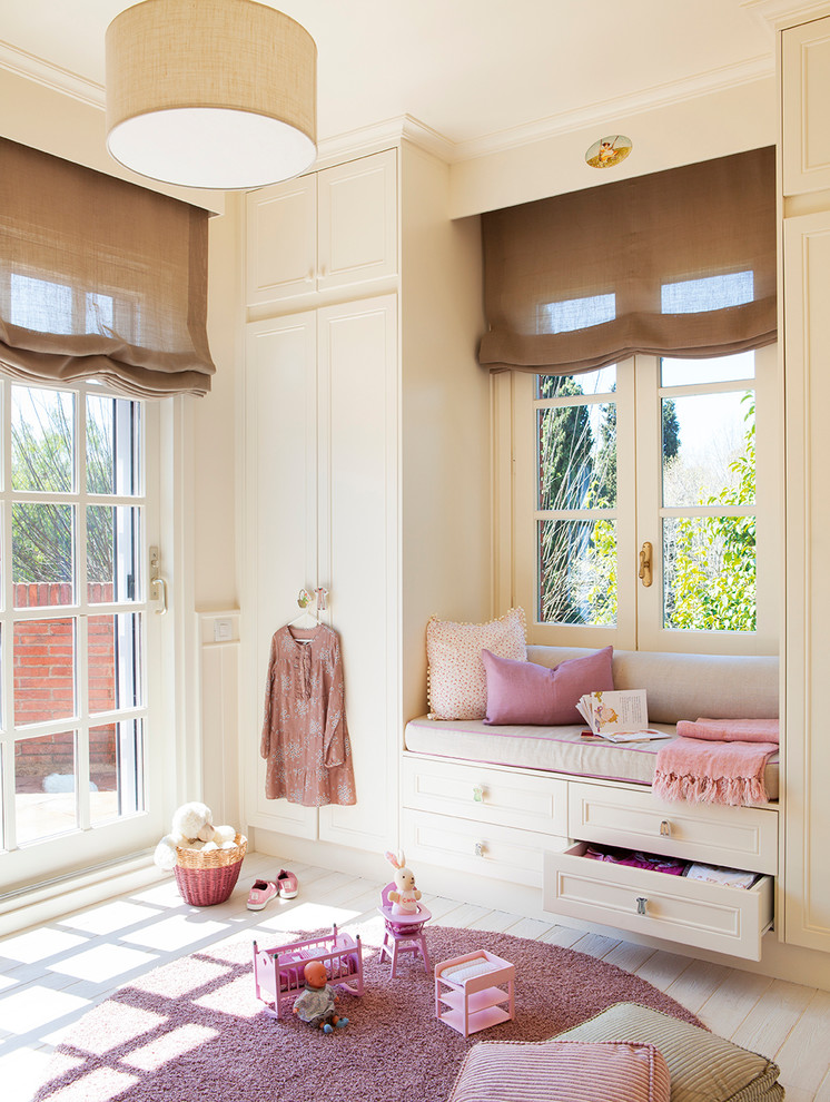 Inspiration for a medium sized contemporary children’s room for girls in Madrid with beige walls, light hardwood flooring and beige floors.