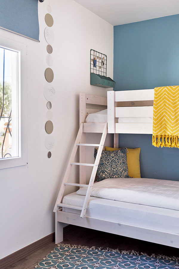 Modelo de dormitorio infantil actual de tamaño medio con paredes azules, suelo laminado y suelo gris