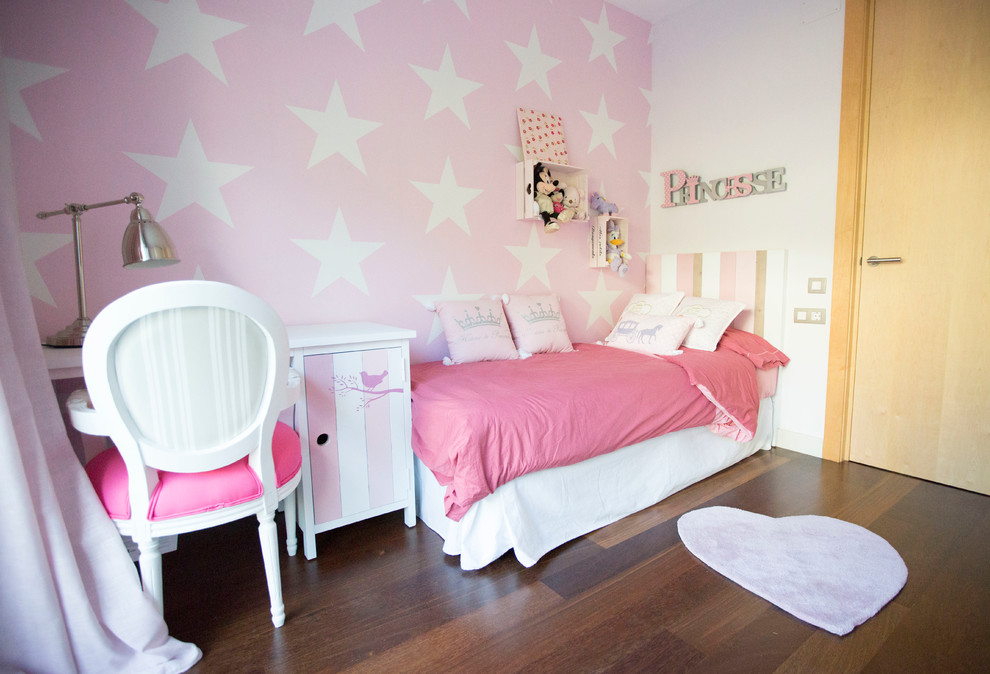 Photo of a medium sized contemporary children’s room for girls in Barcelona with multi-coloured walls and dark hardwood flooring.