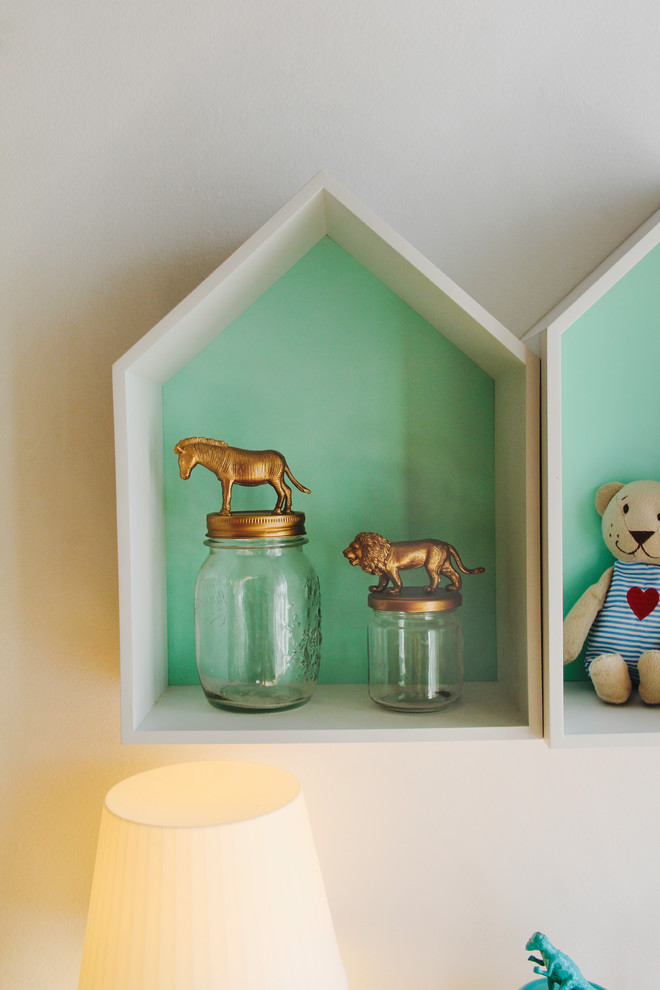 Idée de décoration pour une petite chambre d'enfant de 1 à 3 ans design avec un mur vert et un sol en bois brun.