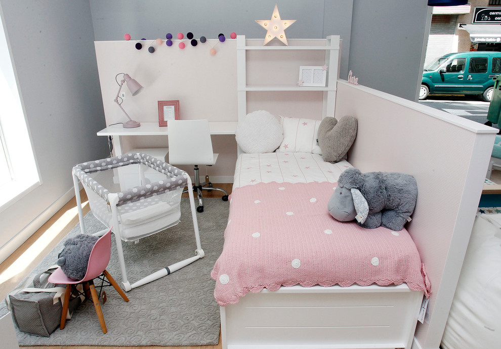 Imagen de dormitorio infantil de 1 a 3 años tradicional renovado pequeño con paredes grises y suelo de madera en tonos medios