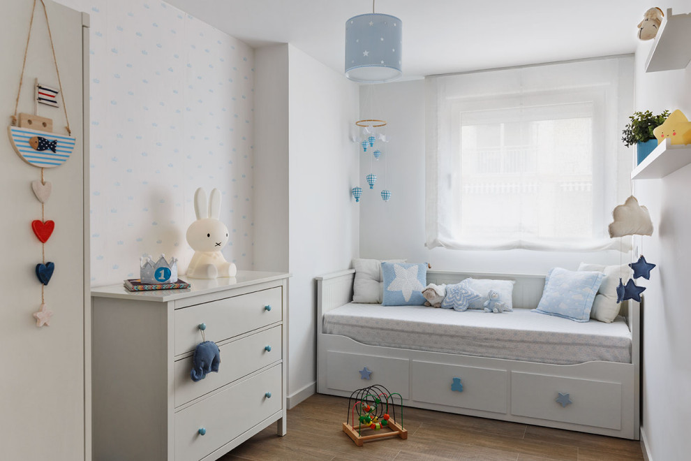 Идея дизайна: детская среднего размера в скандинавском стиле с спальным местом, белыми стенами, полом из керамогранита, коричневым полом и обоями на стенах для ребенка от 1 до 3 лет, мальчика