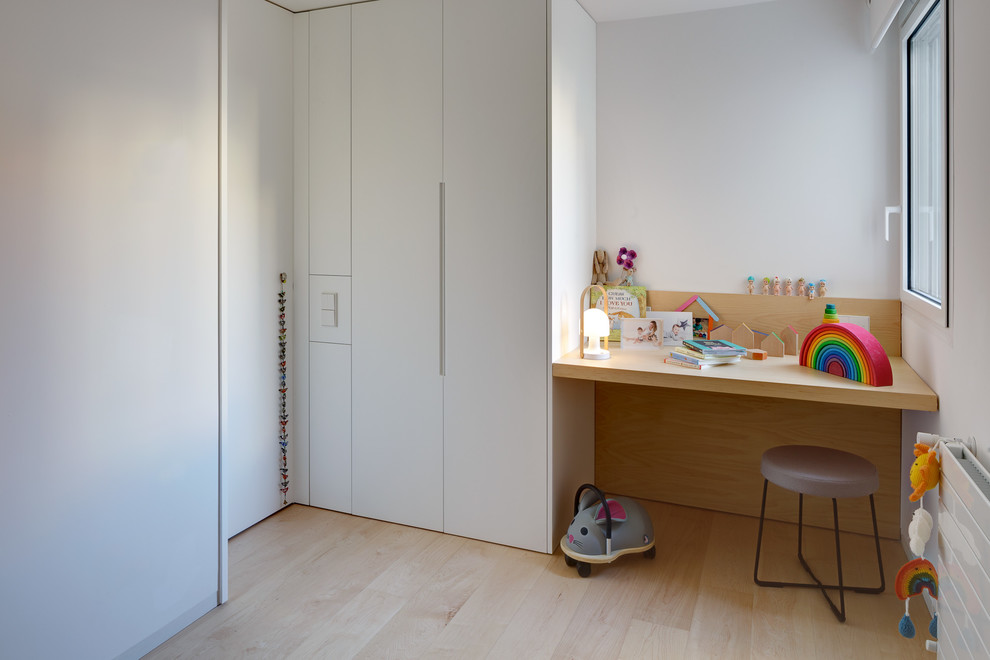 Modelo de dormitorio infantil de 4 a 10 años moderno con paredes blancas, suelo de madera clara y suelo beige