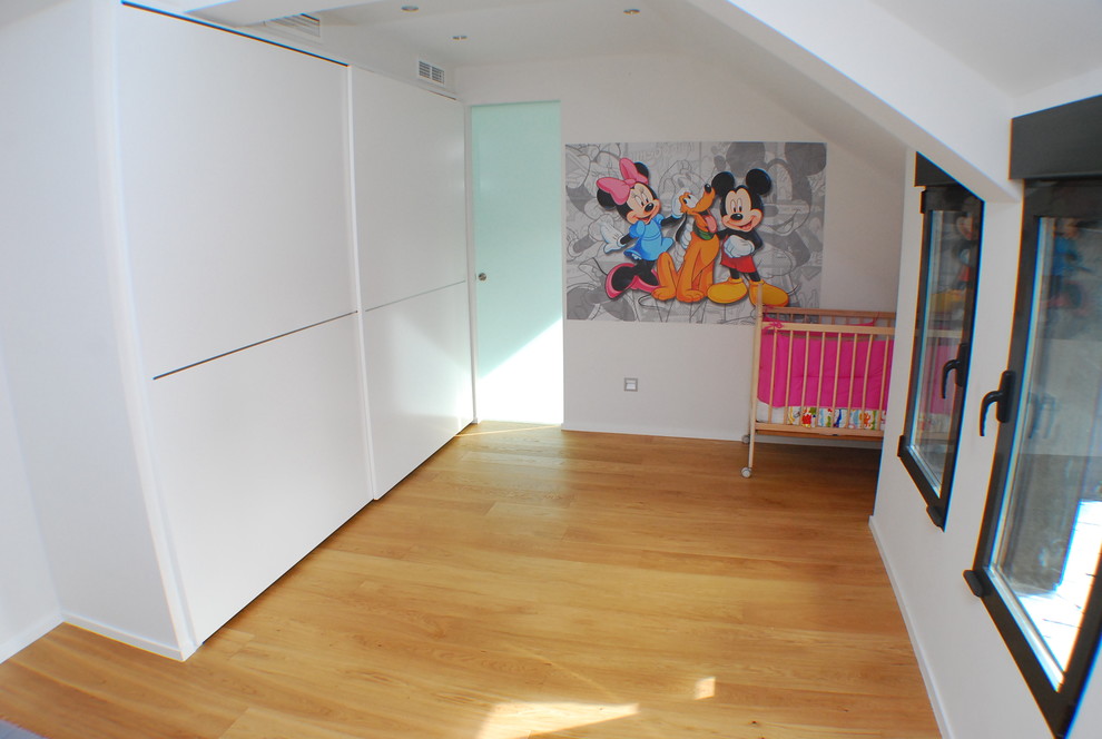 Diseño de dormitorio infantil de 1 a 3 años actual con paredes blancas y suelo de madera clara