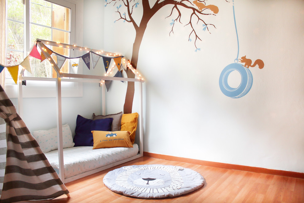 Idee per una cameretta per bambini da 1 a 3 anni minimalista di medie dimensioni con pareti blu, pavimento in laminato e pavimento marrone