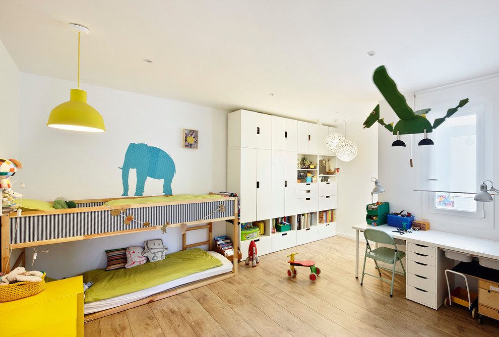 Foto på ett stort funkis könsneutralt barnrum kombinerat med sovrum och för 4-10-åringar, med vita väggar och mellanmörkt trägolv