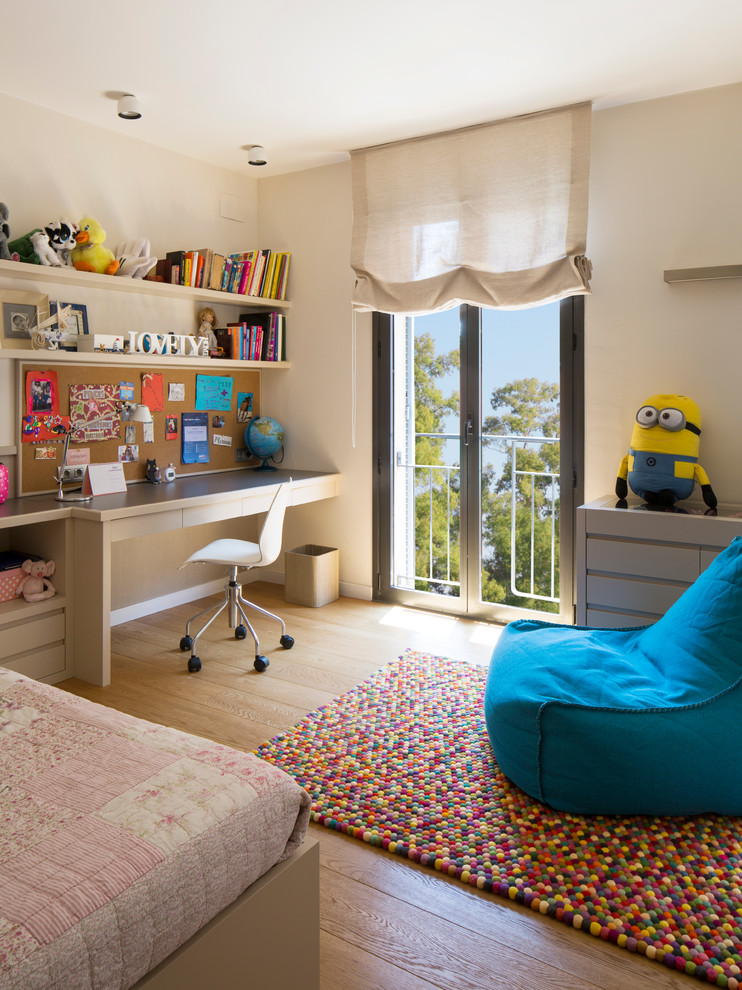 Aménagement d'une chambre d'enfant de 4 à 10 ans de taille moyenne avec un mur beige et un sol en bois brun.