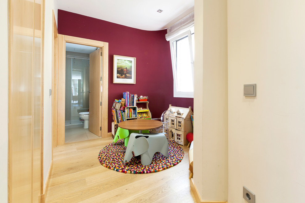 Inspiration för mellanstora moderna könsneutrala barnrum kombinerat med lekrum och för 4-10-åringar, med röda väggar och mellanmörkt trägolv