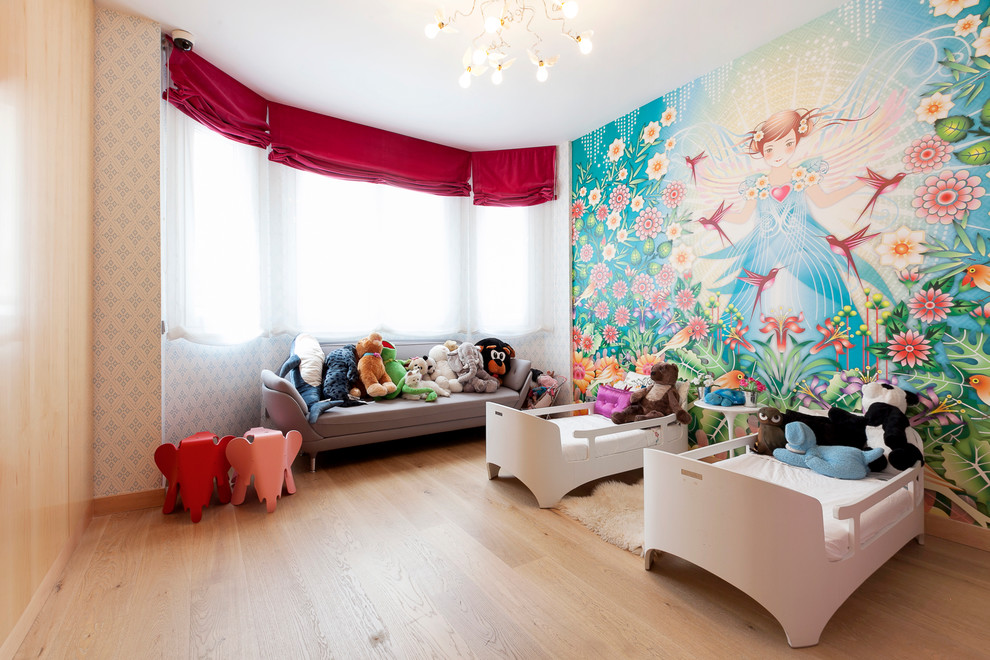 Idéer för att renovera ett stort funkis barnrum kombinerat med sovrum, med flerfärgade väggar och ljust trägolv