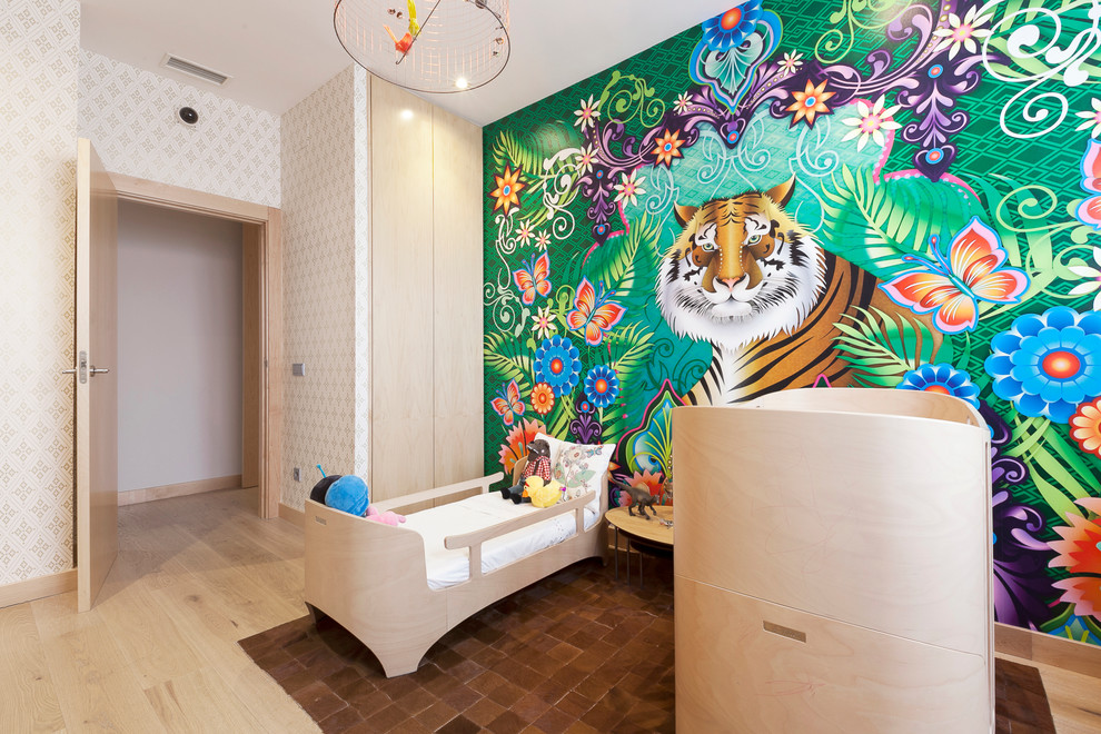 Réalisation d'une chambre d'enfant de 1 à 3 ans ethnique de taille moyenne avec un mur multicolore et parquet clair.