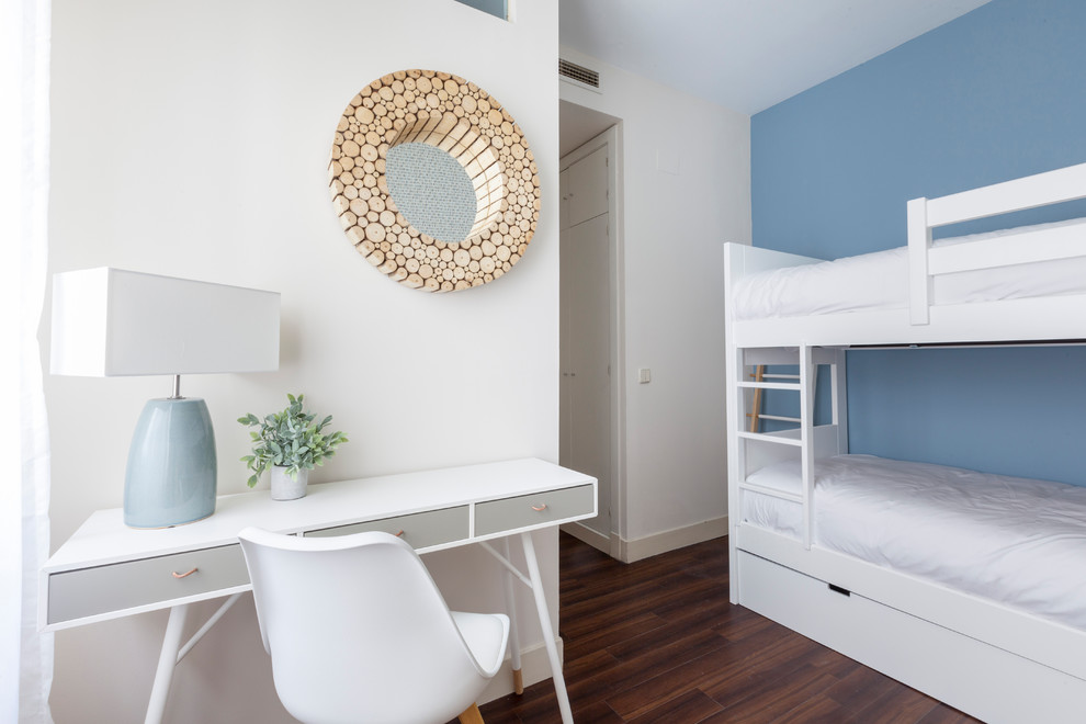 Imagen de dormitorio infantil costero con paredes azules, suelo de madera oscura y suelo marrón
