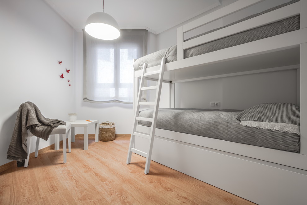 Bild på ett mellanstort minimalistiskt könsneutralt barnrum kombinerat med sovrum och för 4-10-åringar, med vita väggar och mellanmörkt trägolv