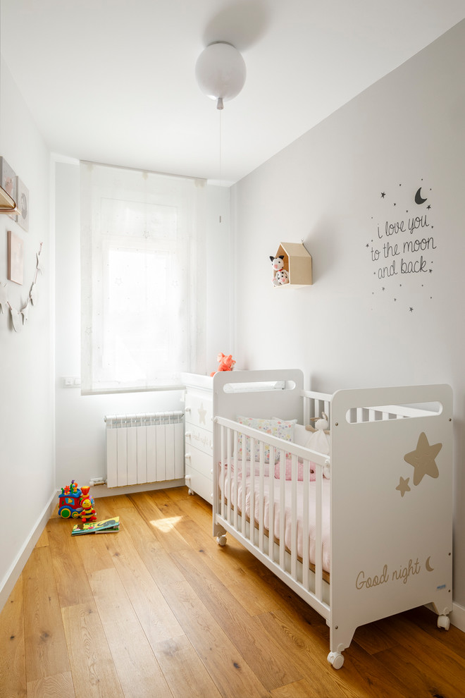 Idéer för medelhavsstil barnrum, med vita väggar och mellanmörkt trägolv