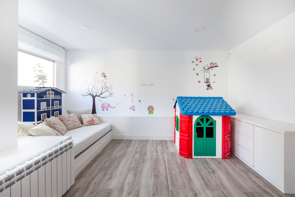 Contemporary toddler’s room for girls in Madrid with white walls and beige floors.