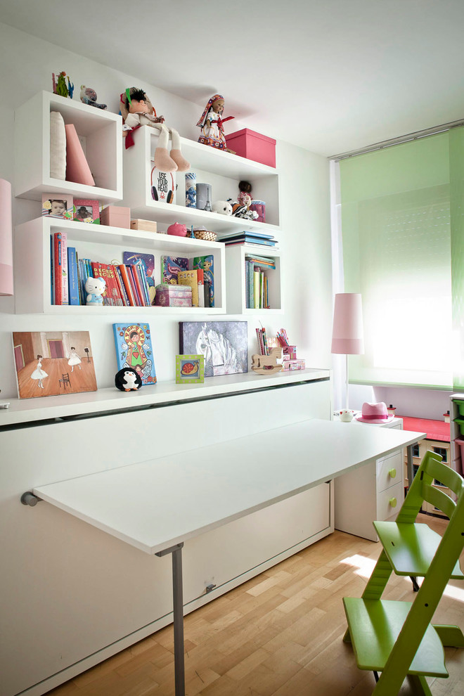 Idéer för ett mellanstort klassiskt könsneutralt barnrum kombinerat med skrivbord och för 4-10-åringar, med vita väggar och mellanmörkt trägolv