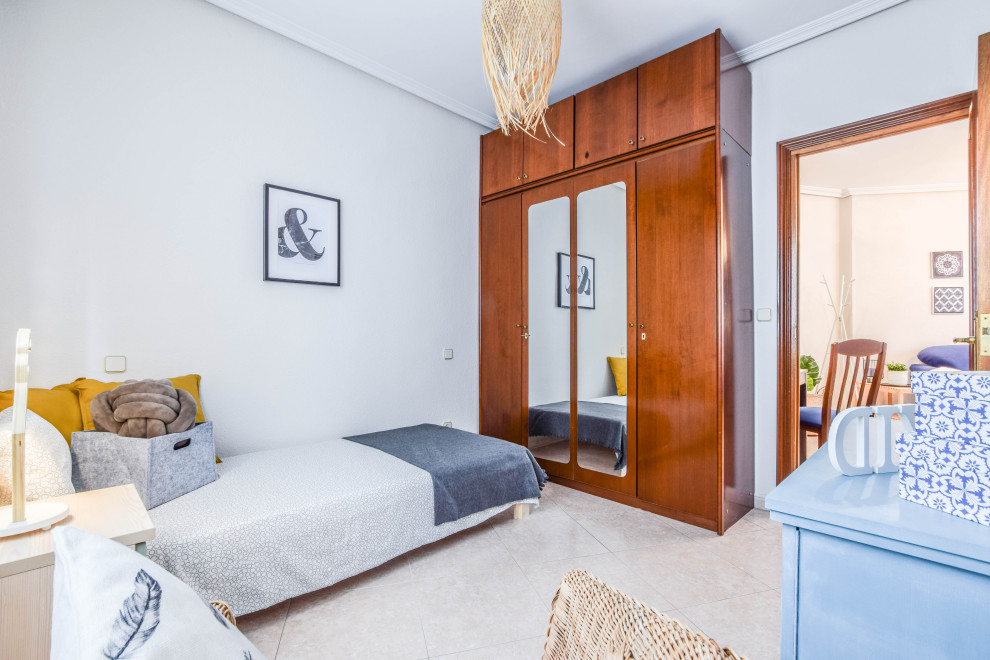Modelo de dormitorio infantil de 4 a 10 años clásico renovado pequeño con paredes blancas, suelo de baldosas de cerámica y suelo beige