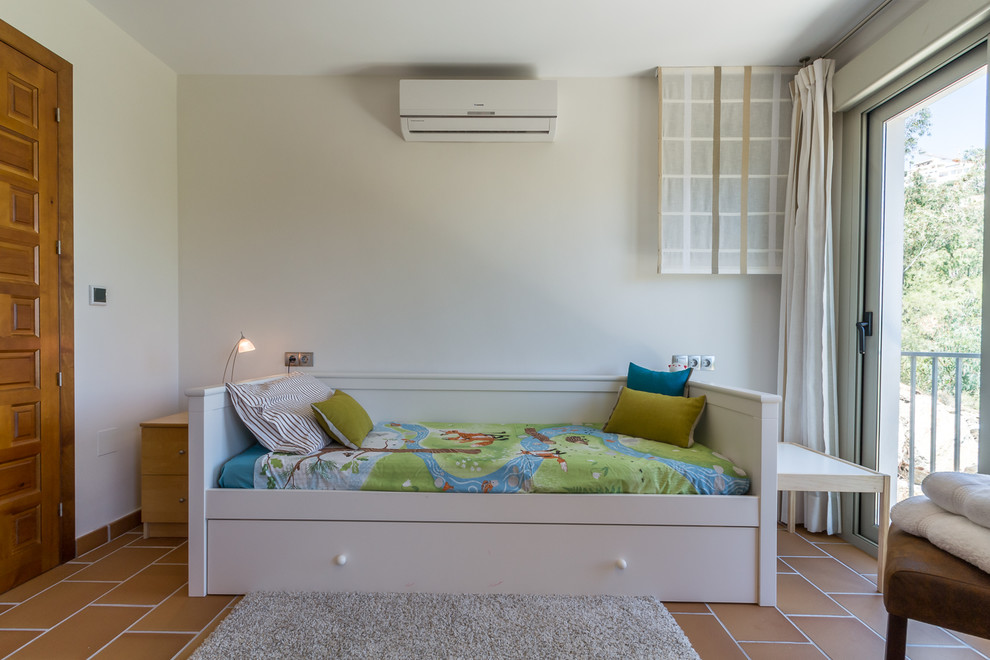 Imagen de dormitorio infantil mediterráneo grande con paredes blancas, suelo de baldosas de cerámica y suelo beige