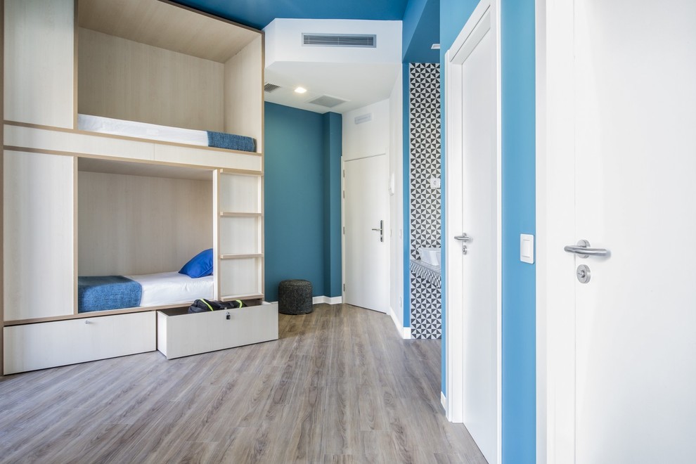 Großes, Neutrales Nordisches Jugendzimmer mit Schlafplatz, blauer Wandfarbe und braunem Holzboden in Madrid