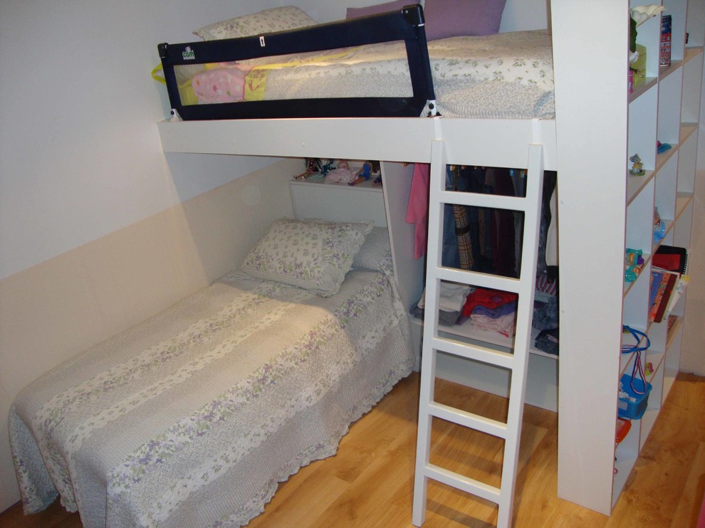 Diseño de dormitorio infantil de 4 a 10 años clásico renovado de tamaño medio con paredes blancas y suelo de madera en tonos medios