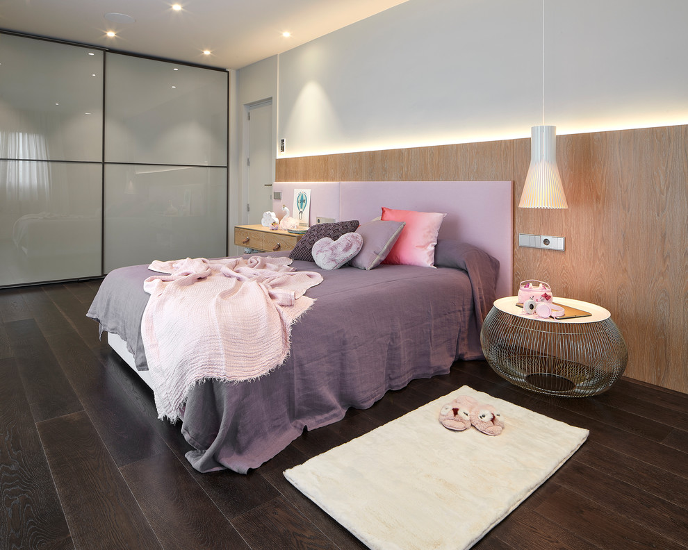 Modelo de dormitorio infantil contemporáneo con paredes blancas, suelo de madera oscura y suelo marrón