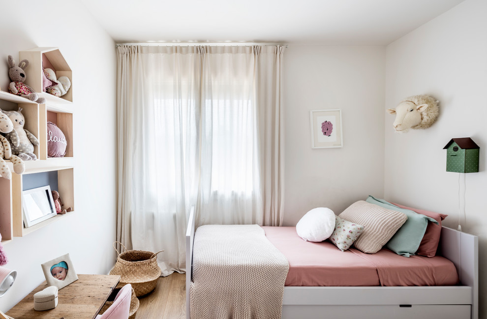 Esempio di una piccola cameretta per bambini da 4 a 10 anni nordica con pareti bianche, pavimento in legno massello medio e pavimento beige