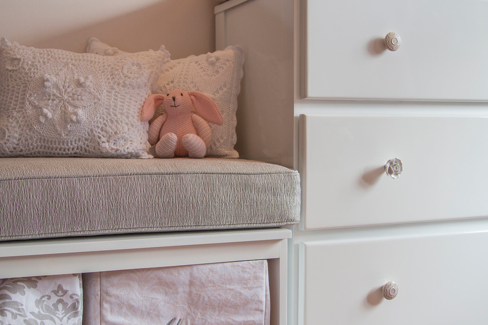 Ispirazione per una piccola cameretta per bambini da 1 a 3 anni shabby-chic style con pareti rosa e pavimento in legno massello medio