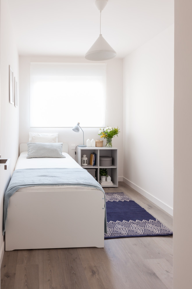 Small danish gender-neutral laminate floor and gray floor kids' room photo in Madrid with beige walls