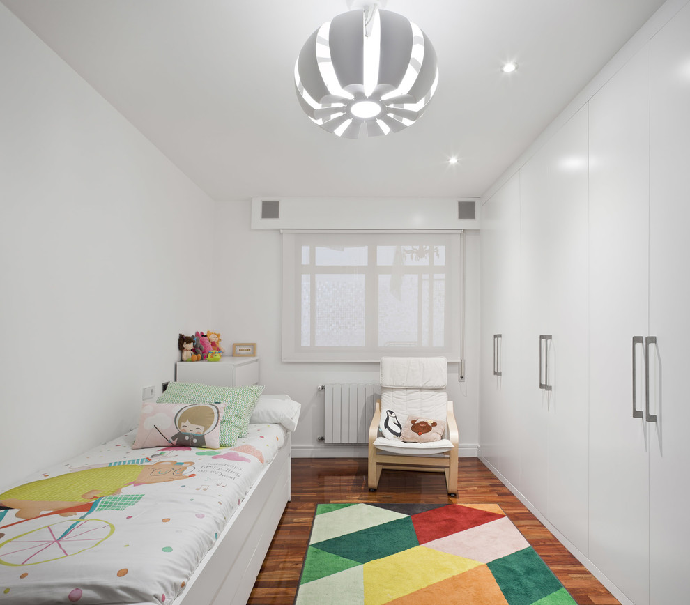 Diseño de habitación de niña de 4 a 10 años contemporánea con paredes blancas, suelo de madera en tonos medios y suelo marrón