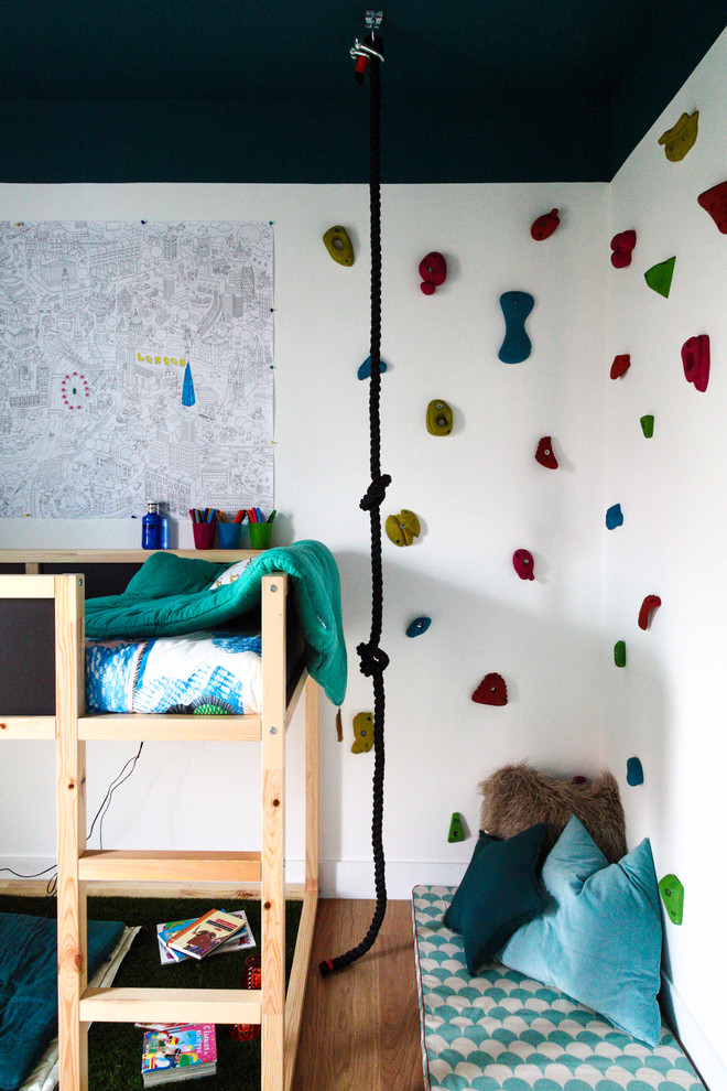 Imagen de dormitorio infantil de 4 a 10 años nórdico de tamaño medio con paredes blancas y suelo de madera en tonos medios