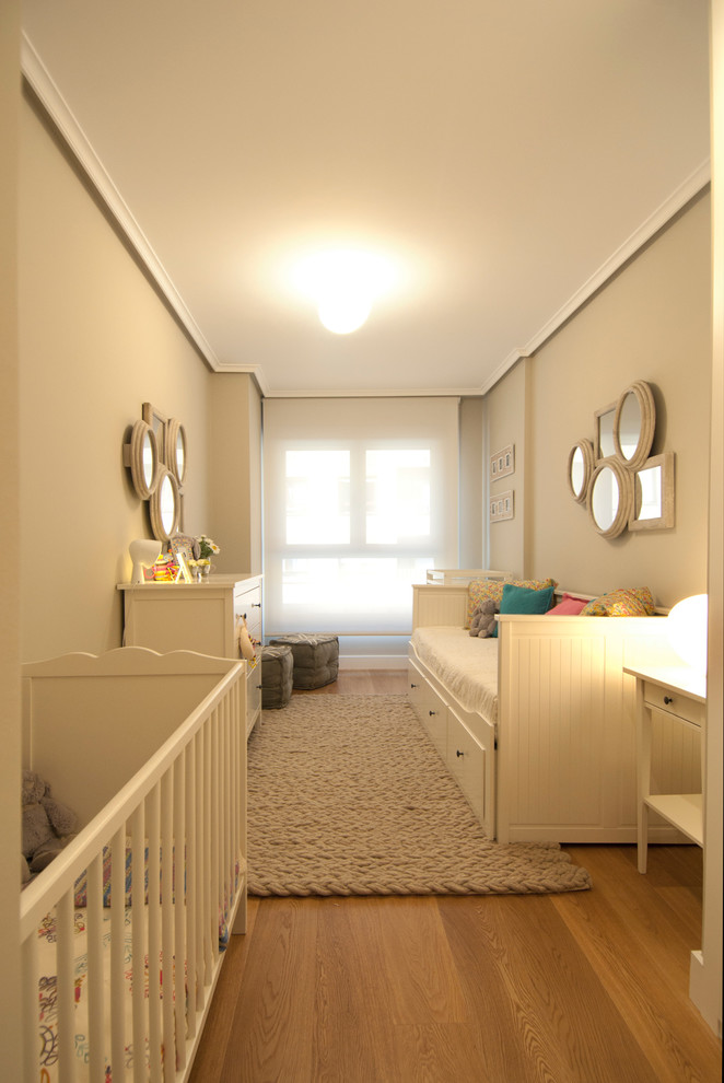 Idéer för vintage könsneutrala småbarnsrum kombinerat med sovrum, med beige väggar och mellanmörkt trägolv