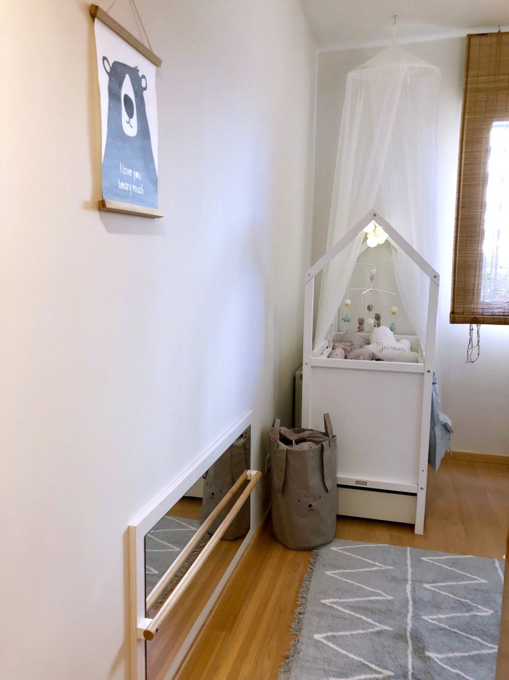 マドリードにある小さな北欧スタイルのおしゃれな子供部屋 (白い壁、ラミネートの床、茶色い床) の写真