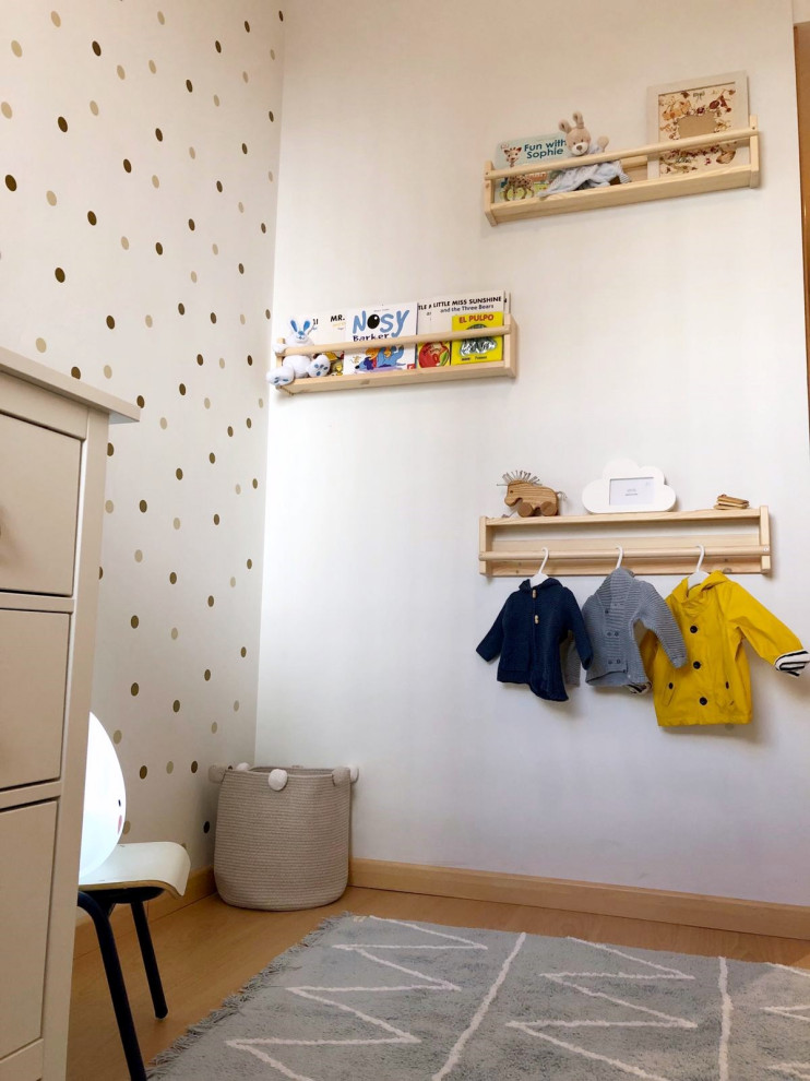 Inspiration for a small scandi toddler’s room for boys in Madrid with white walls, laminate floors and brown floors.