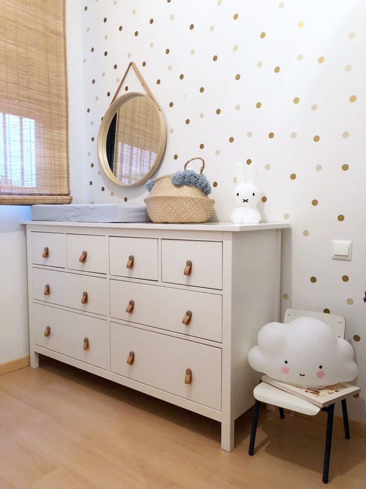 マドリードにある小さな北欧スタイルのおしゃれな子供部屋 (白い壁、ラミネートの床、茶色い床) の写真