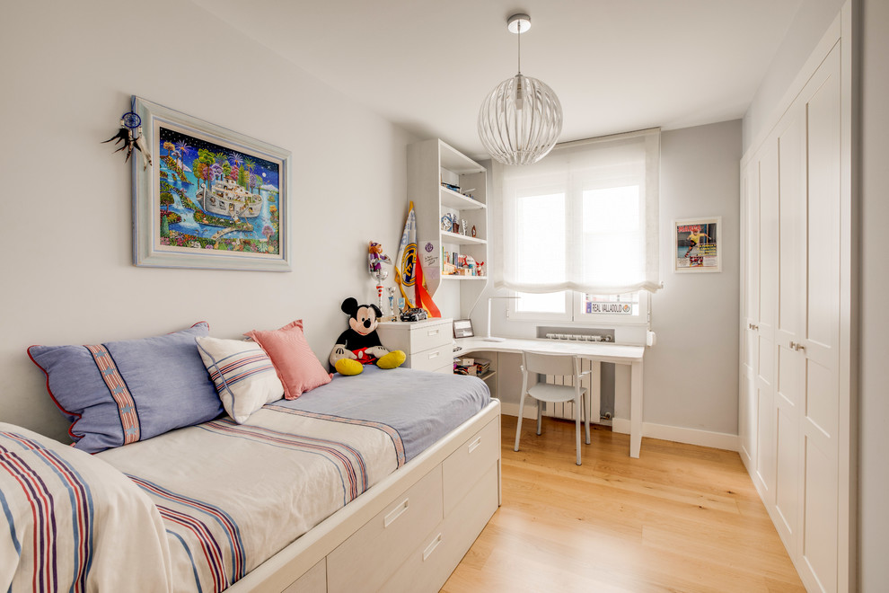 Modelo de dormitorio infantil tradicional renovado con paredes grises, suelo de madera en tonos medios y suelo marrón