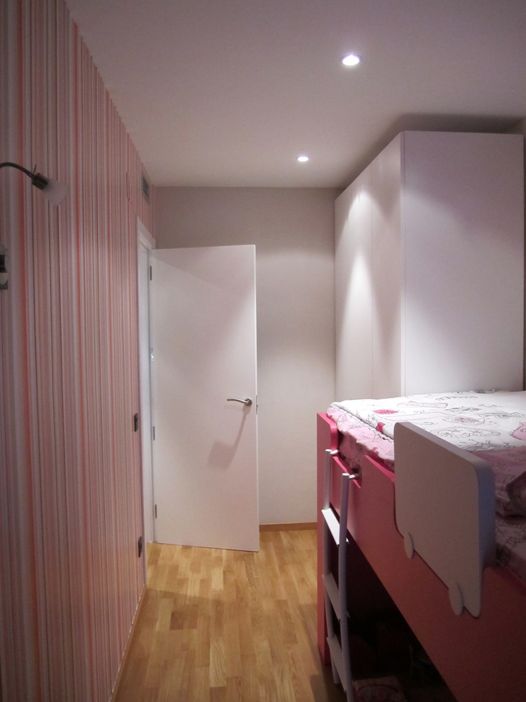 Imagen de dormitorio infantil de 4 a 10 años actual de tamaño medio con paredes rosas y suelo de madera en tonos medios
