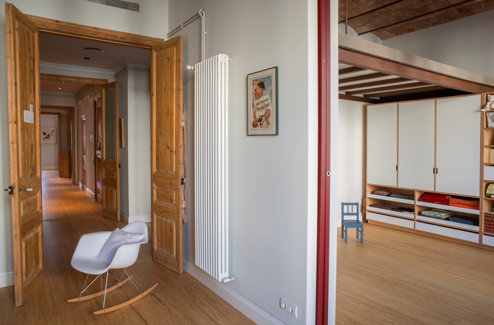 Aménagement d'une chambre d'enfant de 1 à 3 ans scandinave de taille moyenne avec un mur blanc et un sol en bois brun.