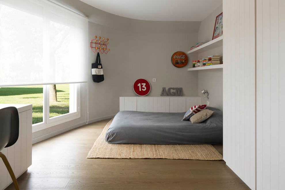 Diseño de dormitorio infantil nórdico de tamaño medio con paredes grises y suelo de madera en tonos medios