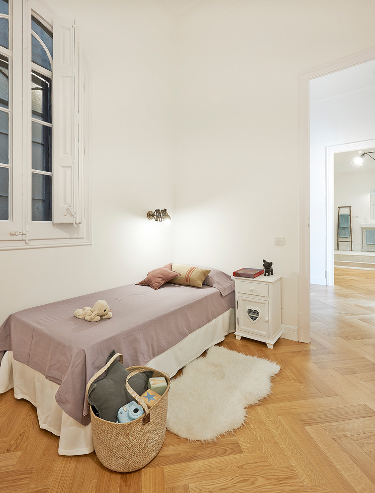 Nordisk inredning av ett mellanstort könsneutralt barnrum kombinerat med sovrum och för 4-10-åringar, med vita väggar och ljust trägolv