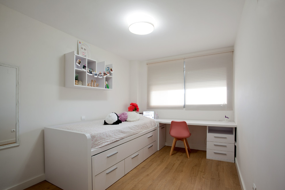 Imagen de dormitorio infantil actual de tamaño medio con suelo laminado y suelo beige