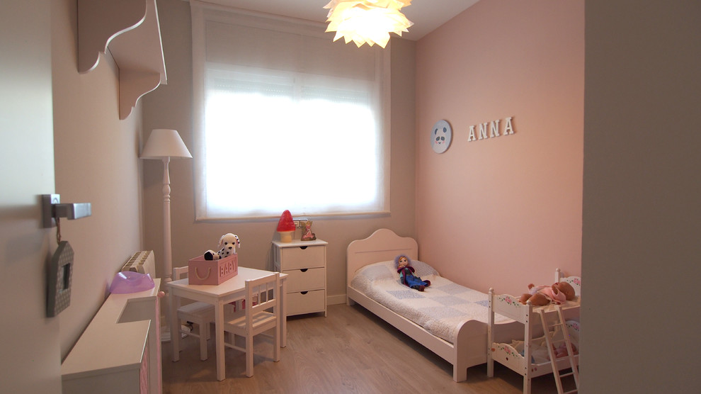 Ejemplo de dormitorio infantil de 4 a 10 años actual de tamaño medio con paredes rosas, suelo de madera clara y suelo beige