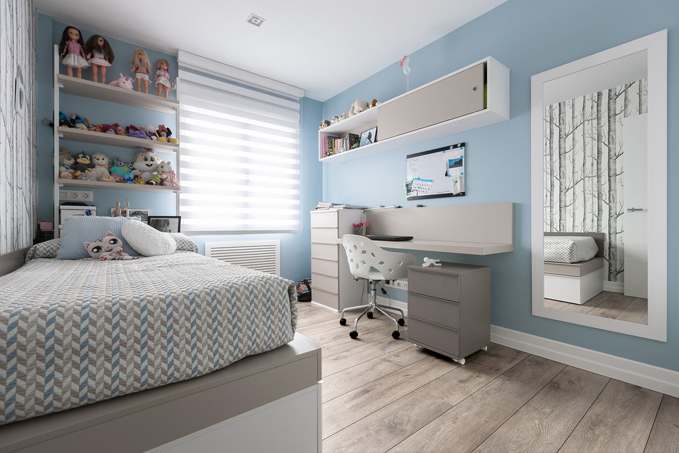 Imagen de dormitorio infantil actual de tamaño medio con paredes azules, suelo de madera en tonos medios y suelo marrón