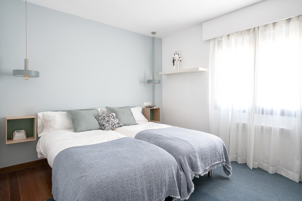 Modelo de dormitorio infantil nórdico de tamaño medio con paredes azules, suelo de madera oscura y suelo marrón