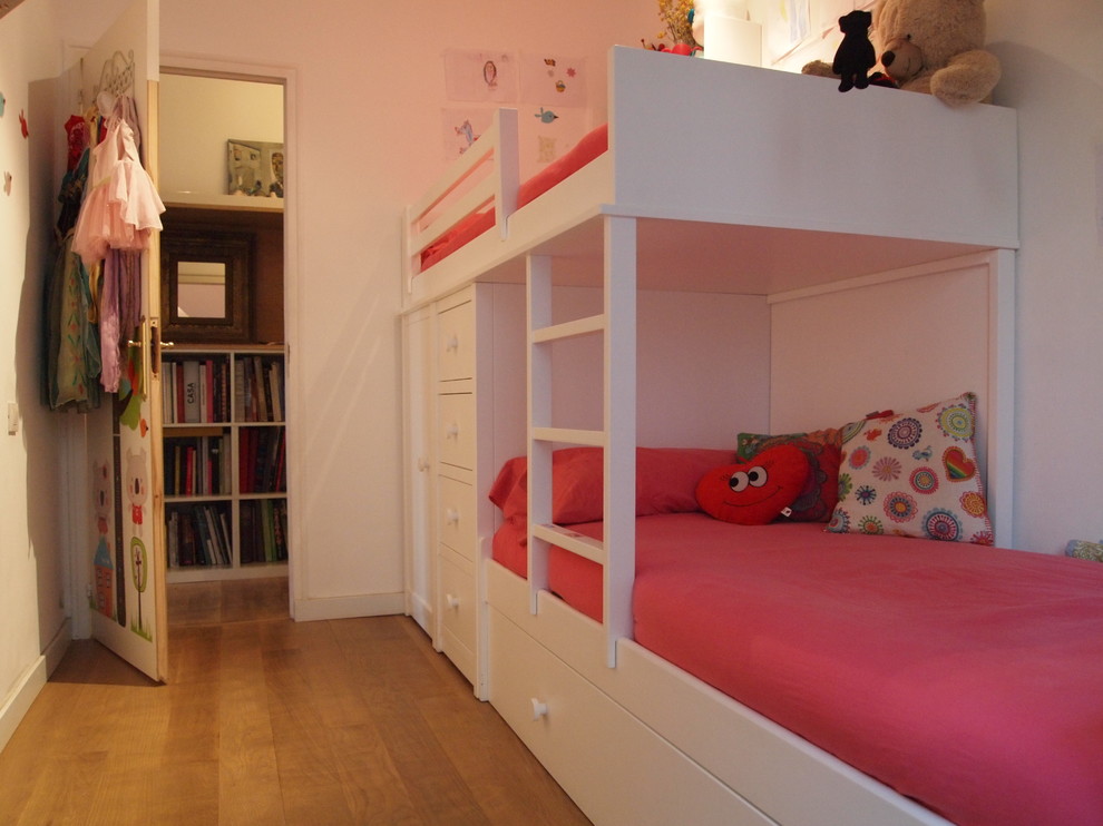 Cette image montre une chambre d'enfant de 4 à 10 ans traditionnelle de taille moyenne avec un mur blanc et un sol en bois brun.