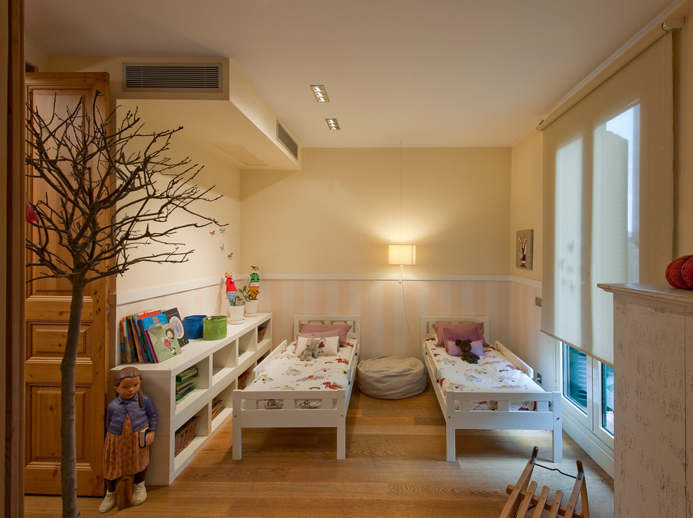 Klassisk inredning av ett mellanstort könsneutralt småbarnsrum kombinerat med sovrum, med gula väggar och mellanmörkt trägolv
