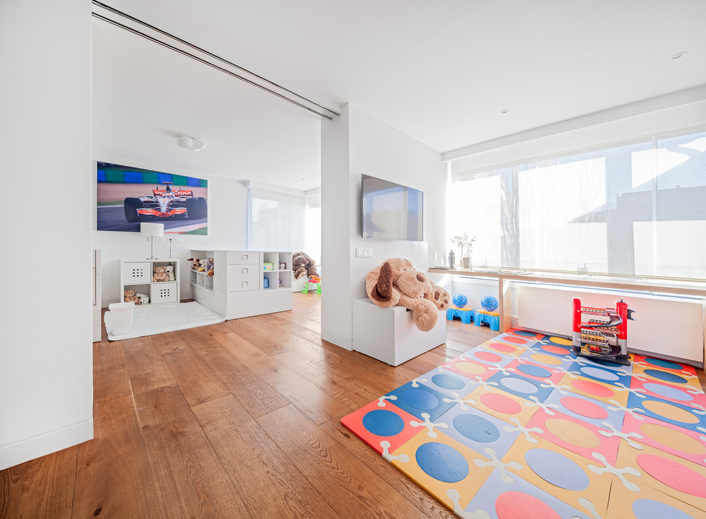 Imagen de dormitorio infantil de 4 a 10 años actual grande con paredes blancas y suelo de madera en tonos medios