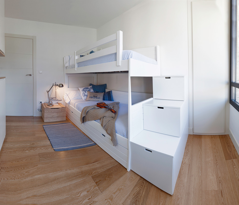 Ejemplo de dormitorio infantil de 4 a 10 años moderno de tamaño medio con paredes blancas y suelo de madera clara