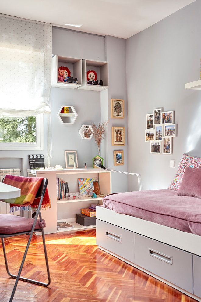 Bild på ett mellanstort funkis flickrum kombinerat med sovrum och för 4-10-åringar, med lila väggar, mellanmörkt trägolv och brunt golv